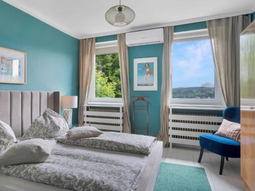 沃尔特湖畔韦尔登Ferienwohnung mit traumhaftem Seeblick的卧室设有两张床铺,拥有蓝色的墙壁和窗户
