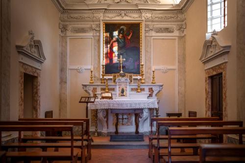 a altar in a church with a painting on the wall at COMO Castello Del Nero in Tavarnelle in Val di Pesa