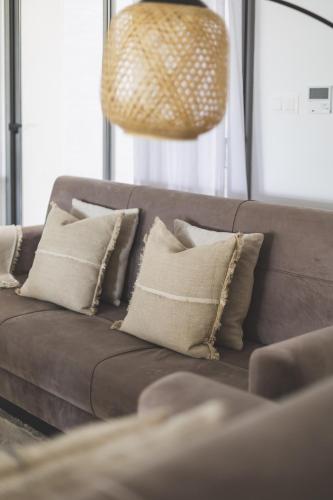 a brown couch with pillows in a living room at Immense appartement 6pièces au Golf in El Mouradia