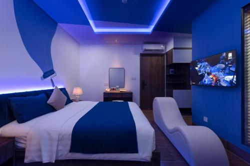 a blue bedroom with a bed and a tv at Chiic House Hotel - Love Hotel in Nha Trang