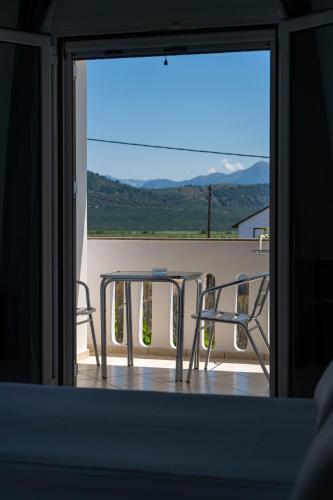 a table and chairs on a balcony with a view at Hotel Alexandros in Ammoudia