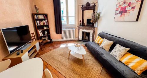 - un salon avec un canapé noir et une cheminée dans l'établissement Hypercenter - At the foot of the Palais des Papes, à Avignon