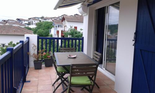 une table et des chaises sur le balcon d'une maison dans l'établissement kantari, à La Celle-sous-Gouzon