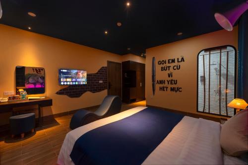 a bedroom with a bed and a desk and a monitor at Chiic House Hotel - Love Hotel in Nha Trang