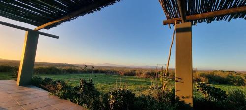 a view from the porch of a house with a view of a field at Living The Breede - Inhoek Farm Gatehouse in Malgas