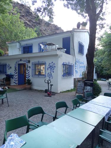 a table and chairs in front of a building at El cortijo azul in Güéjar-Sierra