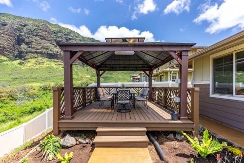 a wooden deck with a table and chairs on it at @ Marbella Lane - Mesmerizing Ocean + MT Views in Waianae
