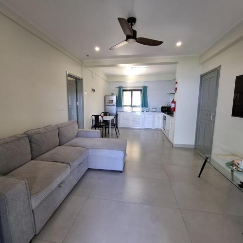 a living room with a couch and a ceiling fan at Tropical Secrets Holiday Apartments in Victoria