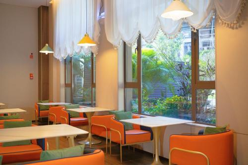 a restaurant with tables and chairs and a large window at Yongchun Laimeng Garden Hotel in Yung-ch'un-hsien