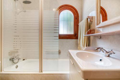 a bathroom with a shower and a sink and a tub at Villa Jeannine in El Tosalet