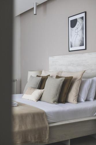 a bed with white and brown pillows on it at Immense appartement 6pièces au Golf in El Mouradia