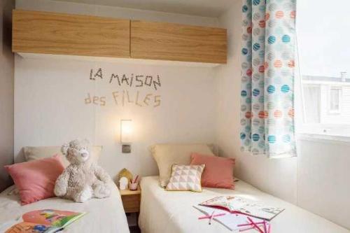 - un ours en peluche assis sur un lit dans une pièce dans l'établissement Camping 3 étoiles - Piscine - ccbbhca, à Pézenas