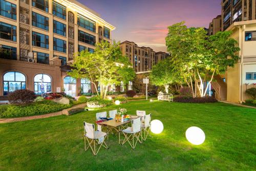 a patio with a table and chairs in the grass at Yongchun Laimeng Garden Hotel in Yung-ch'un-hsien