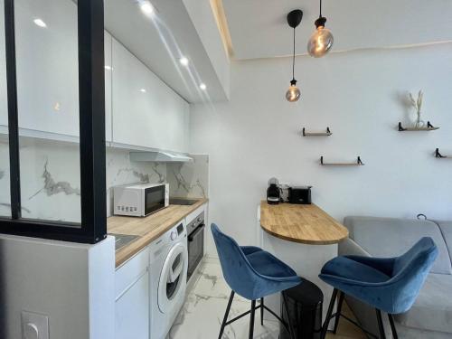 une cuisine avec un lave-linge, une table et des chaises dans l'établissement Nice Signature Andrioli, à Nice