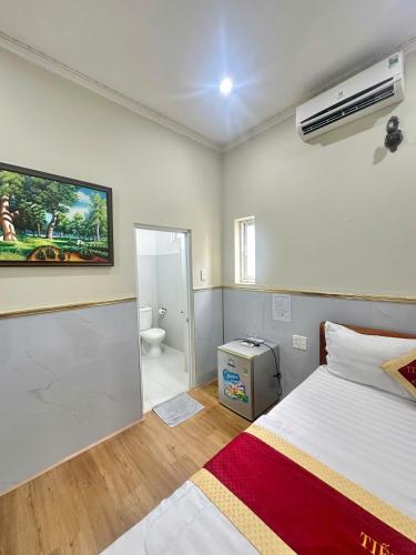 a bedroom with a white bed and a bathroom at Tiến Đạt Hotel Vũng Tàu in Vung Tau