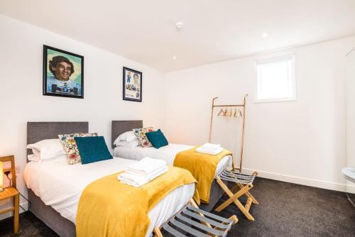 two beds in a room with yellow blankets at Liverpool Waterfront Stay, excellent location , parking available in Liverpool