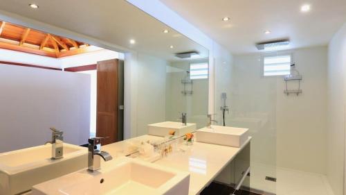 a bathroom with two sinks and a large mirror at Striking Couples Villa Near Toiny Beach in Toiny