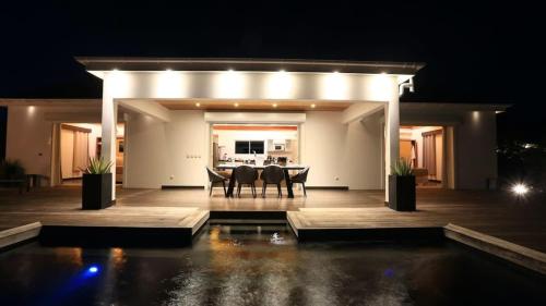 a patio with a table and chairs at night at Striking Couples Villa Near Toiny Beach in Toiny