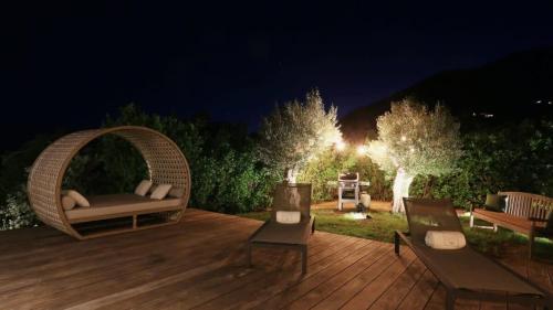 a wooden deck with a wicker chair and a bench at Striking Couples Villa Near Toiny Beach in Toiny