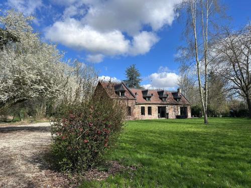 an old house in a grassy field with a tree at Le Paradis 210 m2 en pleine nature in Cambrai