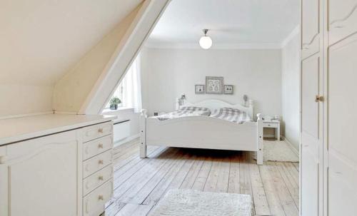 a white bedroom with a bed and a staircase at Large Activity House With Free Access To A Water Park And Bowling 