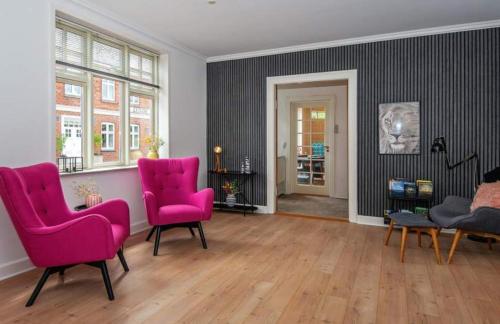 a living room with two pink chairs and a table at Large Activity House With Free Access To A Water Park And Bowling 