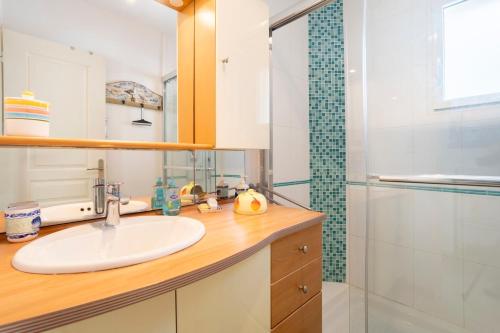 a bathroom with a sink and a shower at Spacieuse maison à 200m de la plage in Combrit
