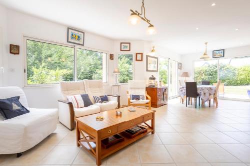 un salon avec un canapé blanc et une table dans l'établissement Spacieuse maison à 200m de la plage, à Combrit