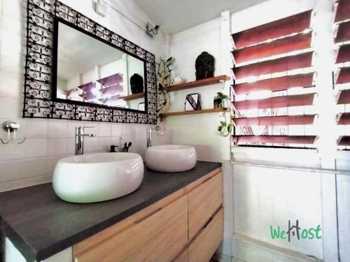 une salle de bain avec un lavabo et un miroir dans l'établissement Villa Iemanjá - St Gilles les bains, à La Celle-sous-Gouzon