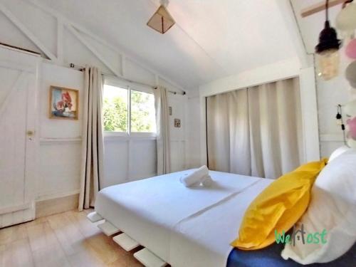 une chambre avec un grand lit blanc et une fenêtre dans l'établissement Villa Iemanjá - St Gilles les bains, à La Celle-sous-Gouzon