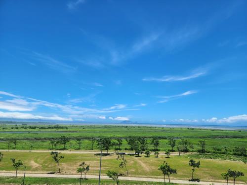 an open field with palm trees and a blue sky at Lanyang Beach Villa in Wujie