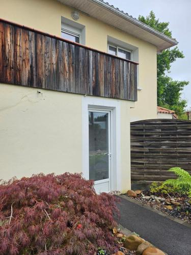 une maison avec une clôture en bois au-dessus dans l'établissement Chambre meublée avec cuisine équipée, à Vic-en-Bigorre