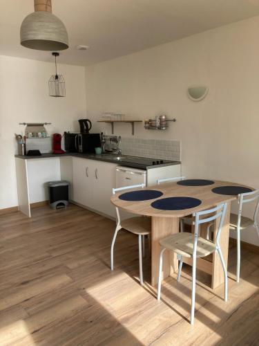 une cuisine avec une table et des chaises dans une pièce dans l'établissement VILLA DEL RE 1 dans résidence avec piscine, à La Flotte