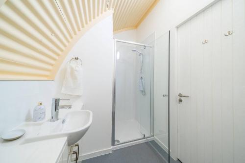 a bathroom with a shower and a sink at Cultybraggan Hut 37 in Comrie