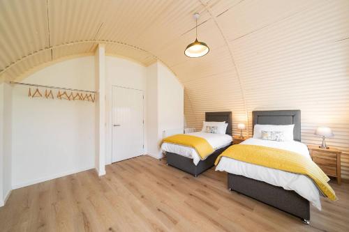 a bedroom with two beds in a room at Cultybraggan Hut 37 in Comrie