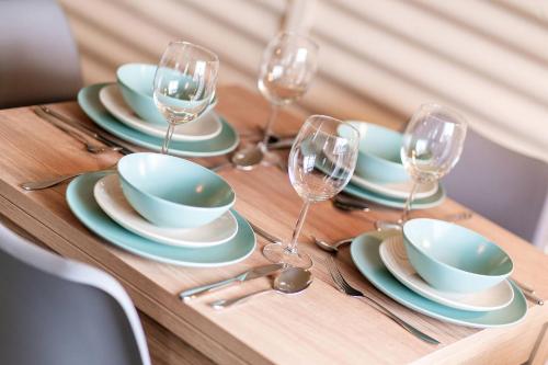 a wooden table with plates and wine glasses on it at Cultybraggan Hut 37 in Comrie
