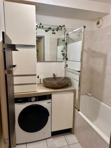 une salle de bain avec un lavabo et une machine à laver dans l'établissement Le jardin des senteurs - 2 pièces avec jardin, à Grasse