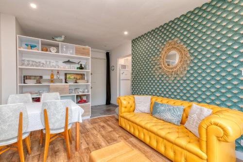 un salon avec un canapé jaune et une table dans l'établissement Appartement des Dryades, cosy 60m2, à La Baule-les-Pins