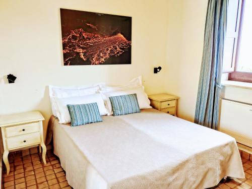 a bedroom with a white bed with two pillows at Bosco Ciancio in Biancavilla