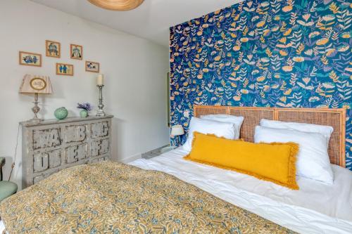 - une chambre dotée d'un lit avec une couverture bleue et jaune dans l'établissement Appartement des Dryades, cosy 60m2, à La Baule-les-Pins
