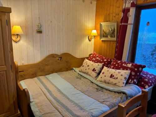 une chambre avec un lit avec des oreillers et une fenêtre dans l'établissement Le Panoramique I Studio, à Thollon-les-Mémises