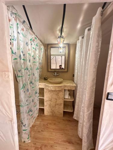 un baño con lavabo y espejo en Your berber camp, en Merzouga