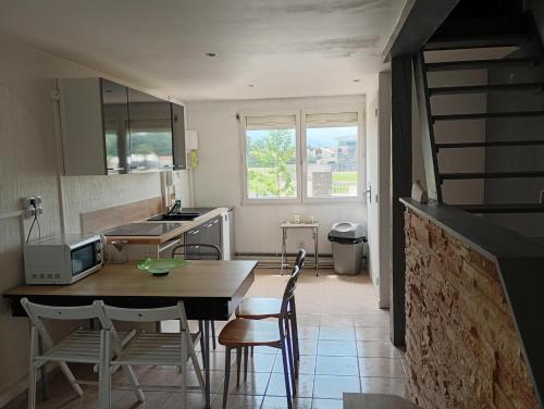 una cucina con tavolo e sedie e una cucina con lavandino di Le clos joli ad Argelès-sur-Mer