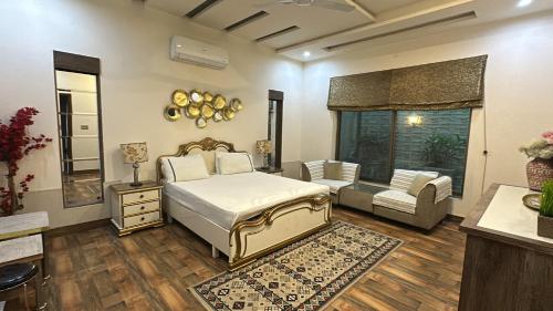 a bedroom with a bed and a couch in a room at Comfortable luxury Bedroom in Faisalabad
