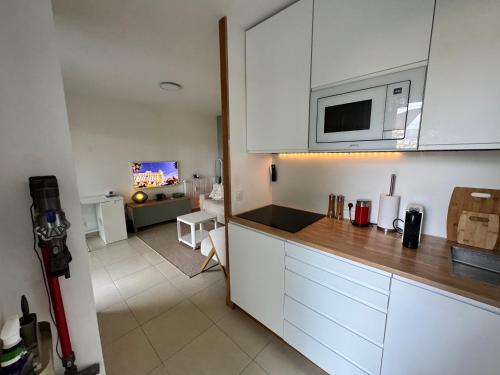 une cuisine avec des armoires blanches et un salon dans l'établissement Art Studio Nice, à Nice