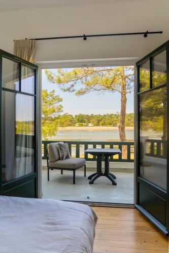 - une chambre avec un balcon doté d'une table et d'une chaise dans l'établissement Villa Art Deco luxe vue imprenable sur la lac d Hossegor Clim, à Hossegor