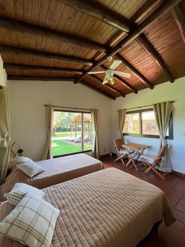 a bedroom with two beds and a ceiling fan at Cabañas Lodge el Suizo 2 in Gobernador Virasora
