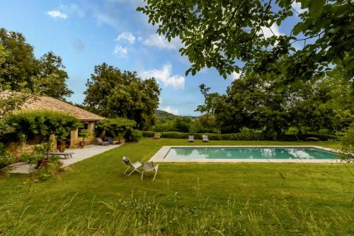 une cour avec une piscine et une maison dans l'établissement La Borie du chateau de Caudon, à Domme