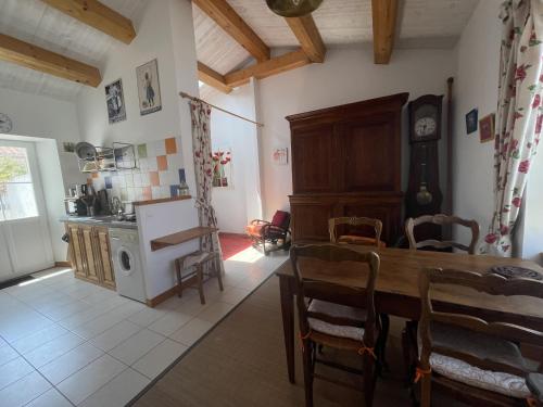 une cuisine et une salle à manger avec une table et une horloge dans l'établissement La Maison du Marin, à Saint-Gilles-Croix-de-Vie