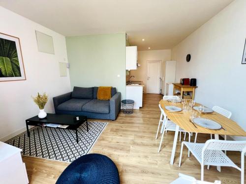 un salon avec une table et un canapé dans l'établissement Le Ferte - Coeur de ville, à La Rochelle
